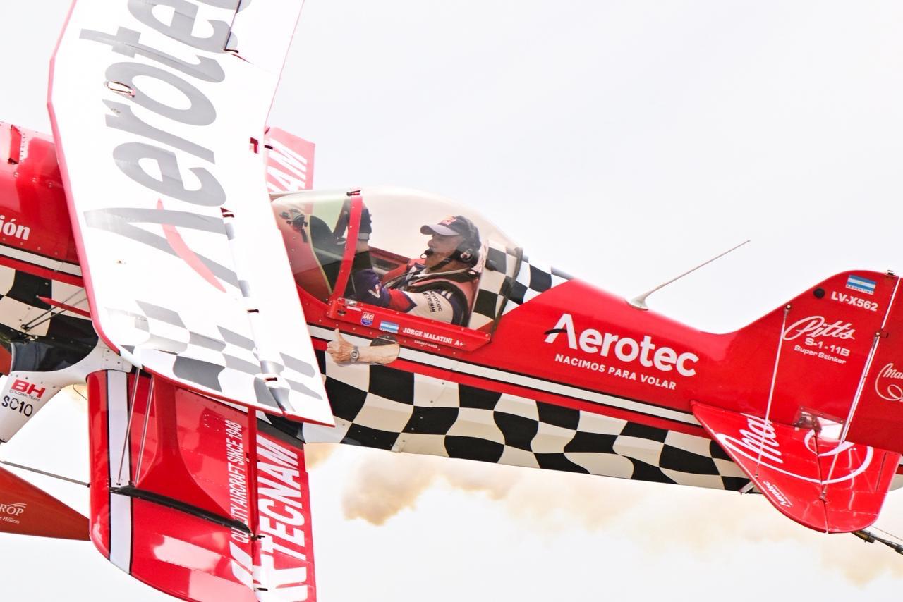 Piloto realizando una demostracion acrobatica en una aeronave roja