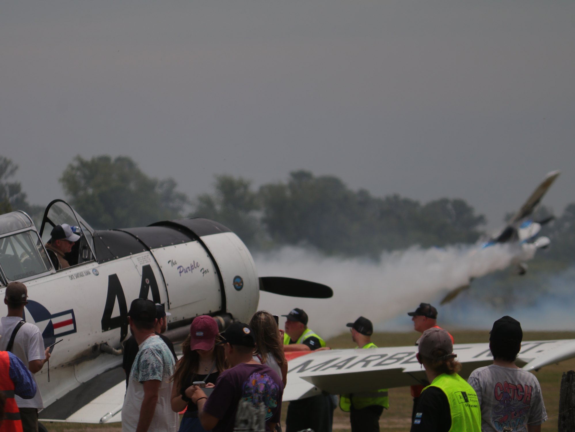 Publico recorriendo la exposicion junto a una aeronave historica