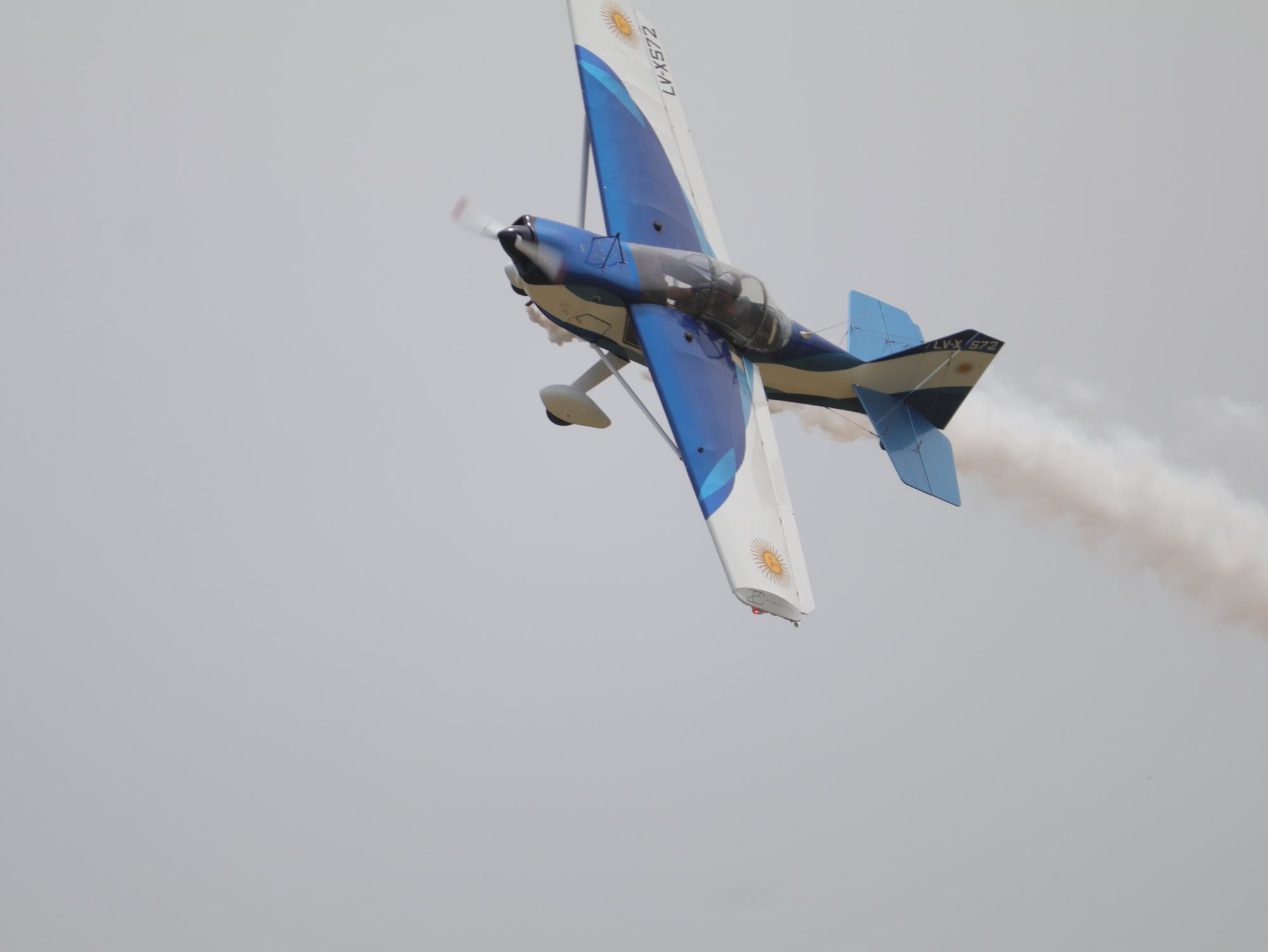 Aeronave acrobatica azul realizando una maniobra en vuelo