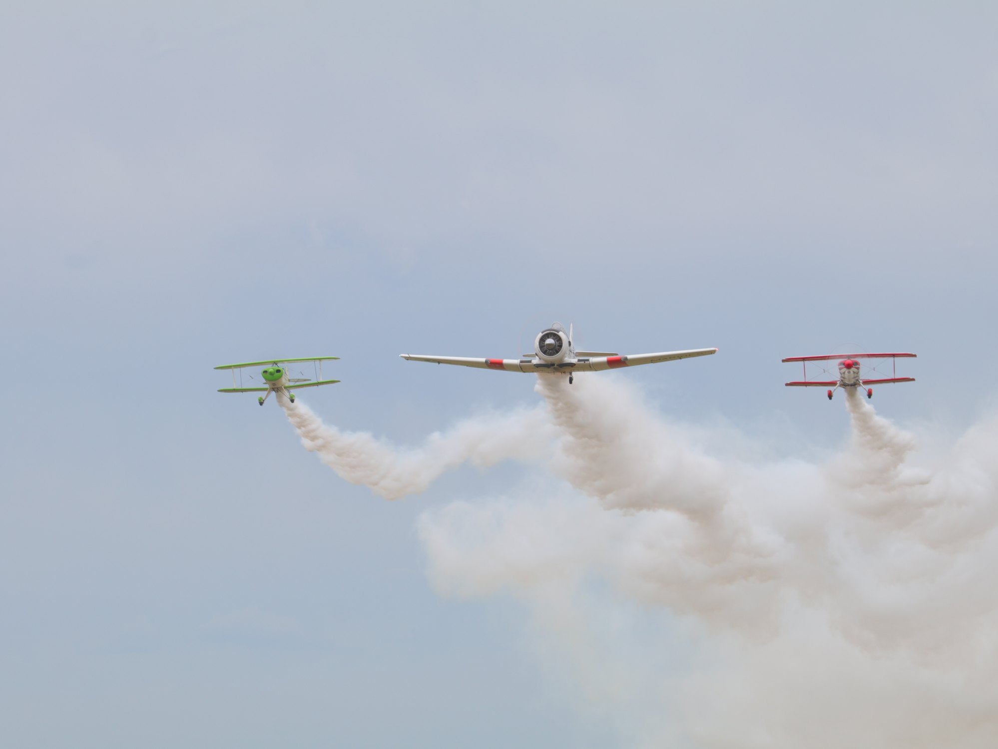 Tres aeronaves avanzando en formacion con estelas de humo